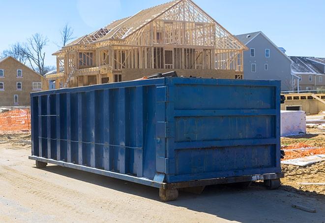 a series of residential dumpsters aligned for evening collection